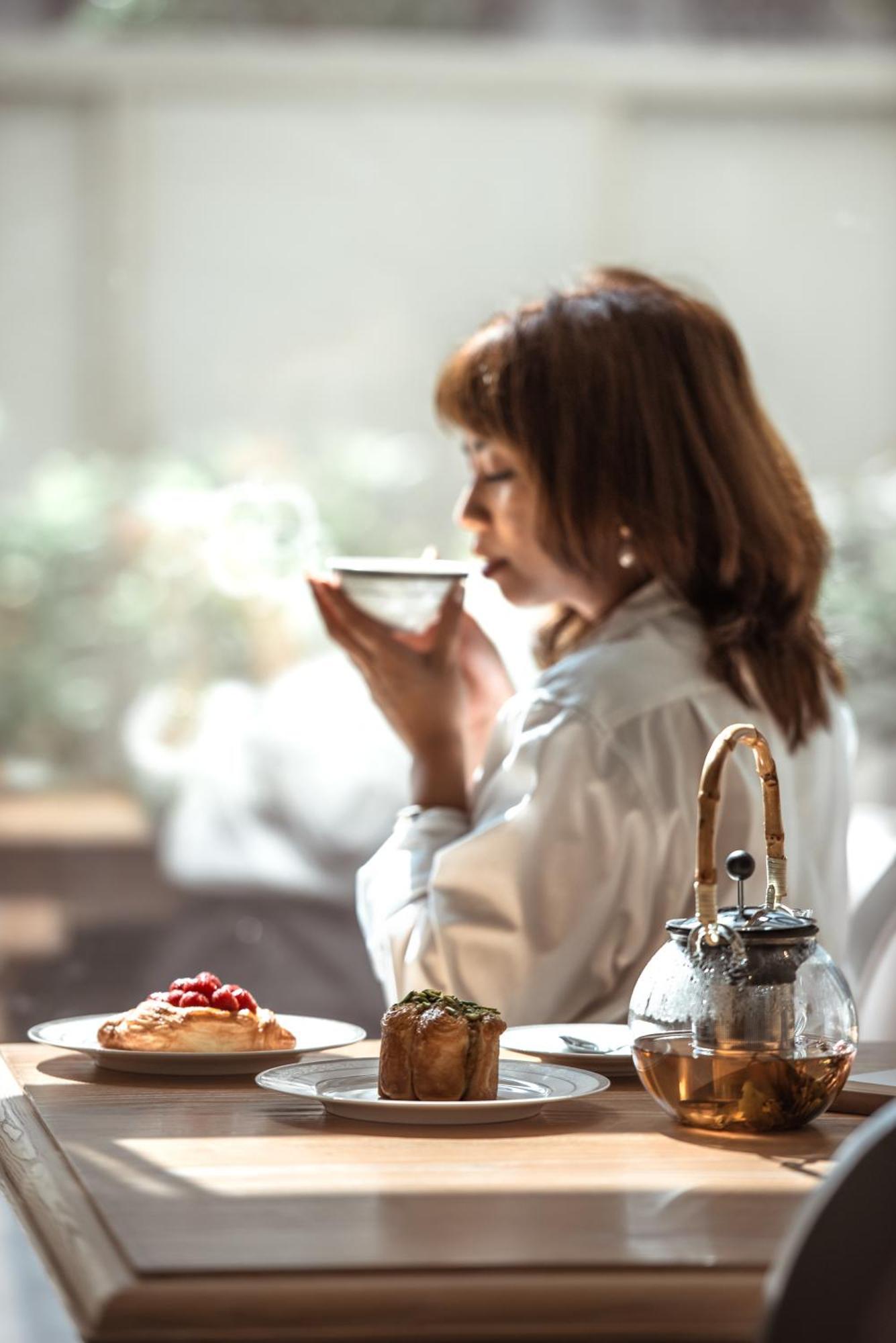 Dusit Doha Hotel Exterior photo A woman drinking tea